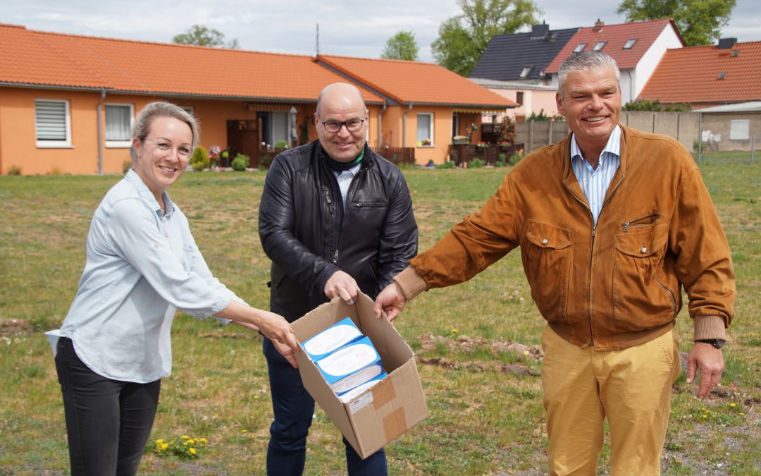 Katrin Lindgreen, Pflegedienstleiterin im Wohnpark Colbitz, und Dr. Jörg Biastoch nehmen 400 Masken von Holger Stahlknecht und dem CDU-Landesverband Sachsen Anhalt entgegen.