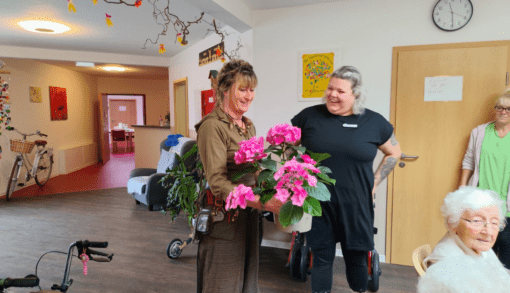 Für ihren Einsatz bei der Weltreise bedankte sich Pflegedienstleiterin Melissa Alberts (r.) zum Abschluss mit einem Blumenstrauß bei Diana Mittendorf im Wohnpark Grieben. Foto: Humanas