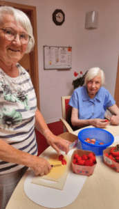 Zwei Bewohnerinnen unterstützen im Wohnpark Osterwieck beim Putzen der Erdbeeren. Foto: Humanas