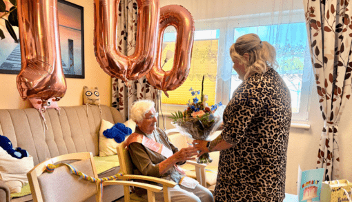 Pflegedienstleiterin Melissa Alberts gratuliert Wera Tiedge herzlich zu ihrem 100. Geburtstag und überreicht einen Blumenstrauß.