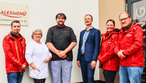 Adrian Krotki, Geschäftsführer von Alexmenü (3. v. r.) mit seinem Team: Fuhrparkleiter Sascha Johannsen (v. l.), Monika Kohls, Produktentwicklerin und Köchin, Robin Sticherling, Teamleiter der warmen Küche und Koch, Prokuristin Isabell Scheller und Robert Mucha, Kundenbetreuer bei Alexmenü. Foto: Humanas